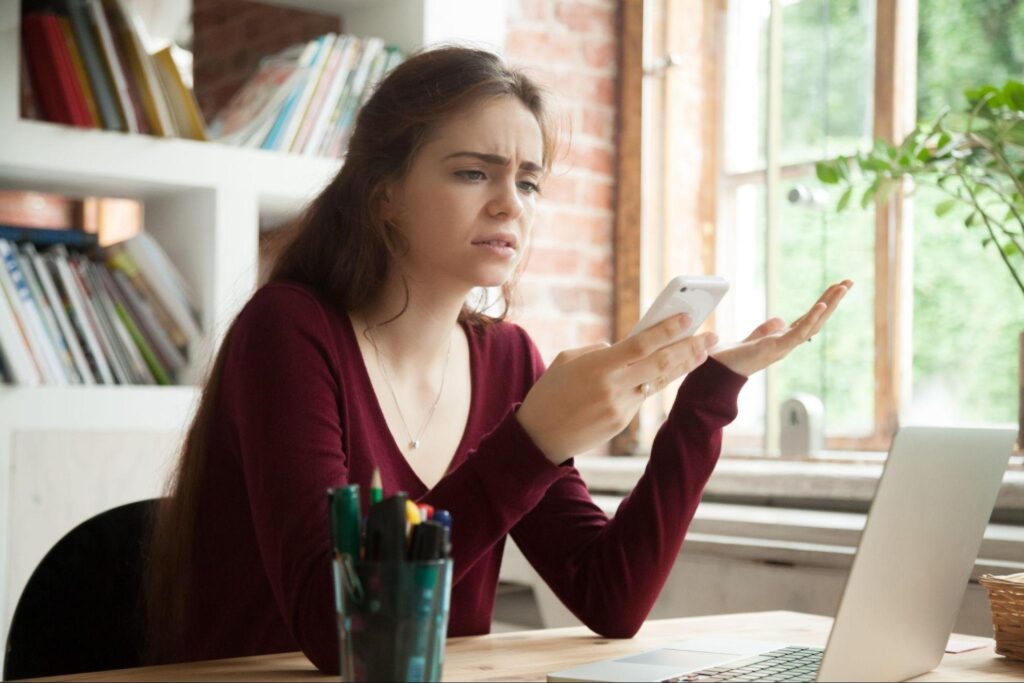 frustrated woman with phone in hand