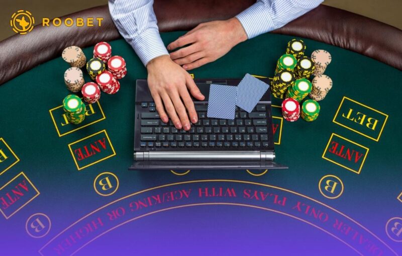 An image of a laptop, chips, and cards on the table